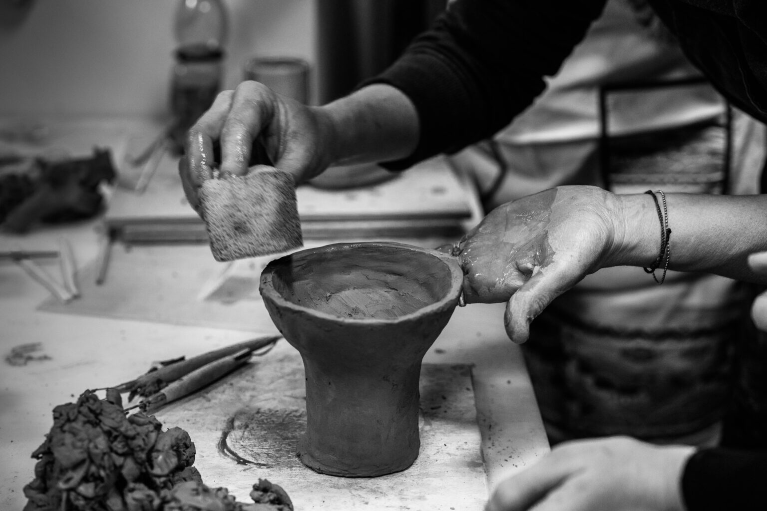 Hands working clay at a ceramics workshop in Le Marche, Italy — black and white